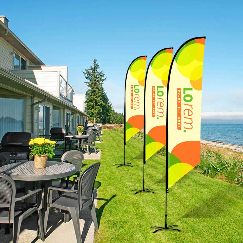 Row of feather flags on a lawn by the water